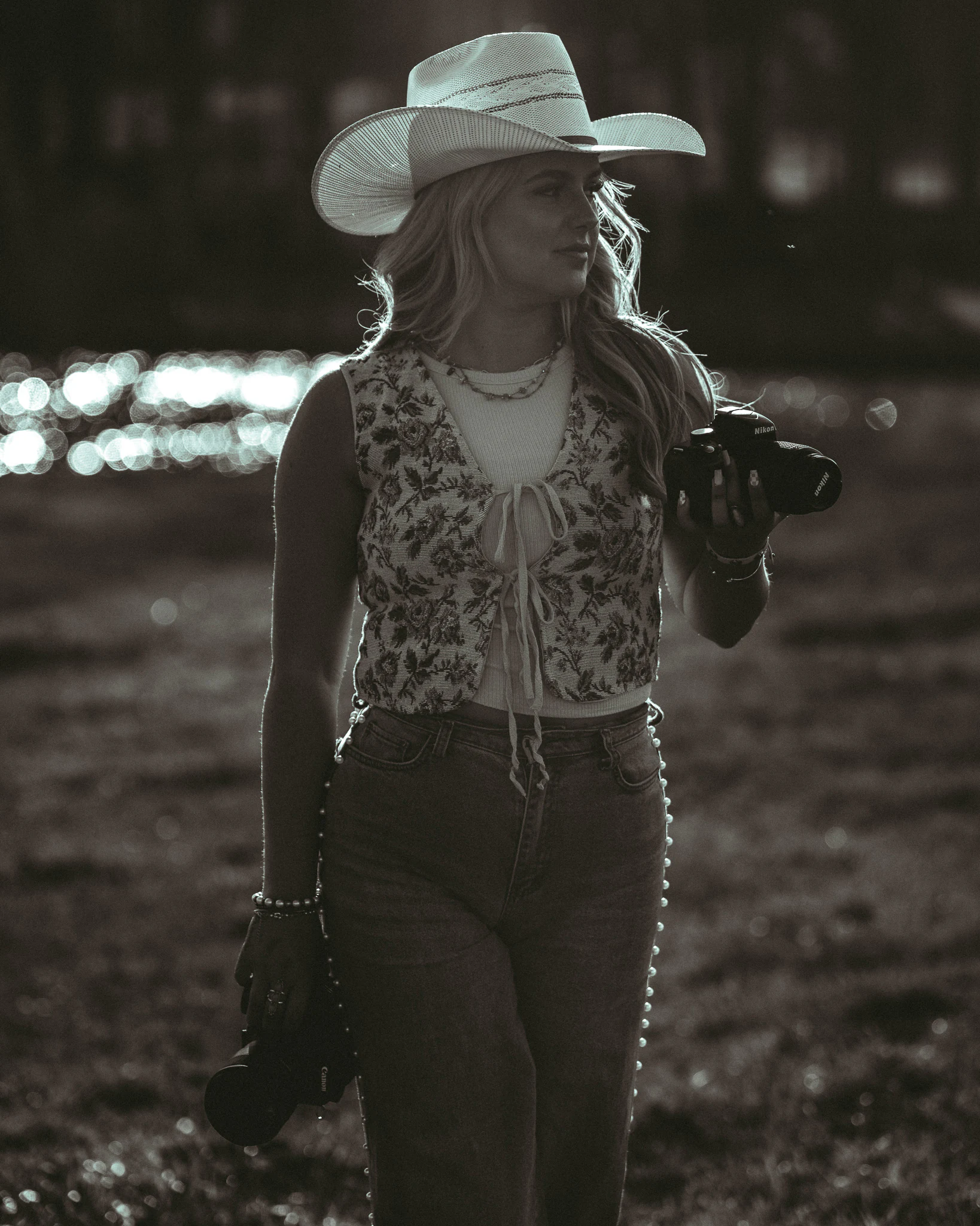 Jayda holding two cameras in a black-and-white portrait